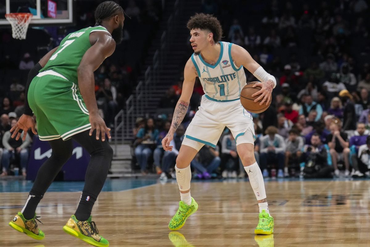 LaMelo ball dribbles as Jaylen Brown defends him